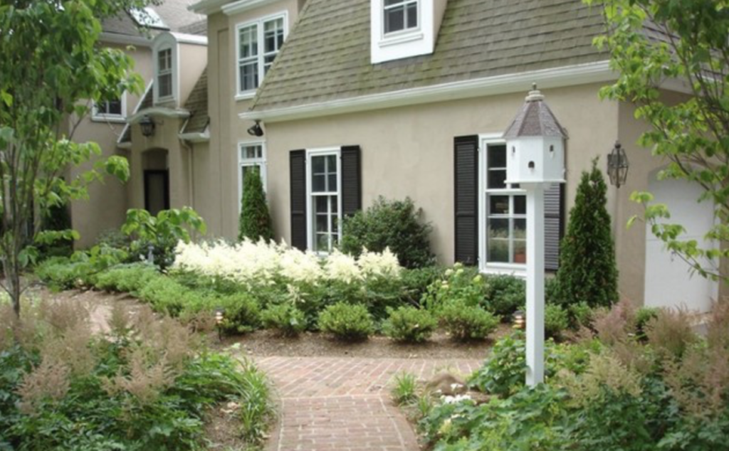 PA front door with bushes, trees, and flowers